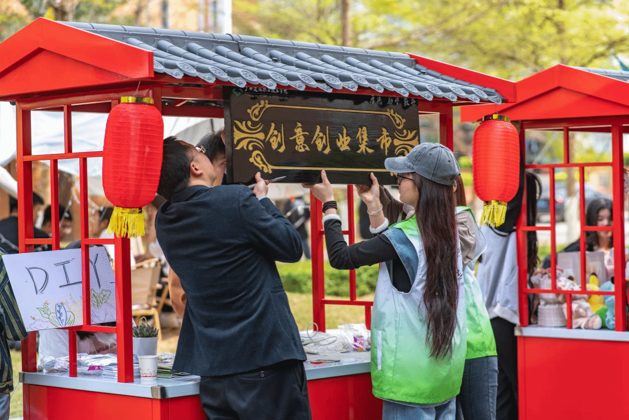 校团委曾小贵书记到现场与同学们一起挂装集市牌匾