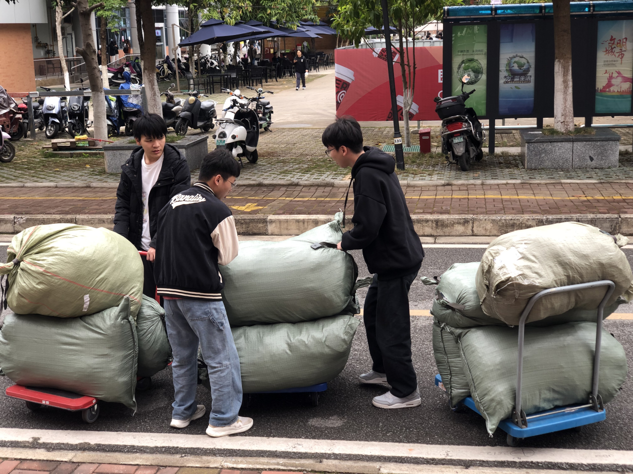 管理工程学院易班学生工作站值班同学搬运军训服