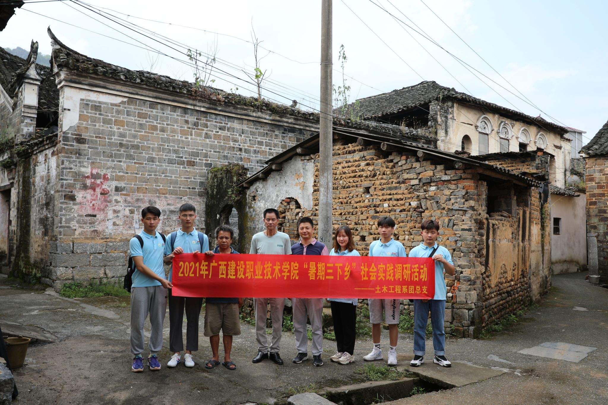 实践团成员在历史民居前与石脚村村民合影