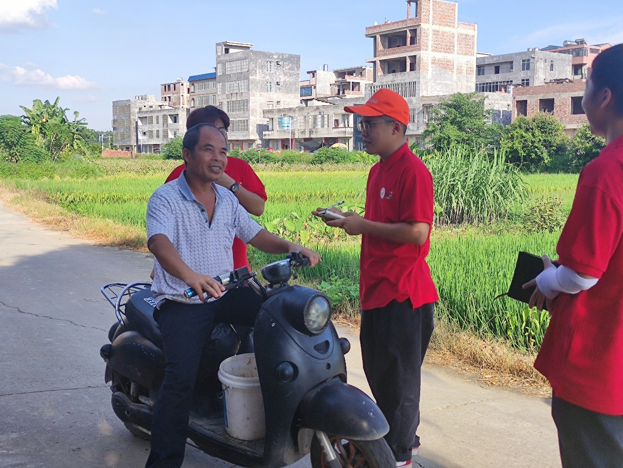 实践团成员在田间地头与当地村民进行交流